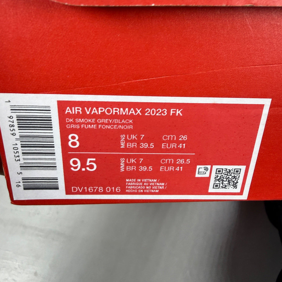 Nike athletic shoes grey Flyknit upper with Air VaporMax sole and logo detail.