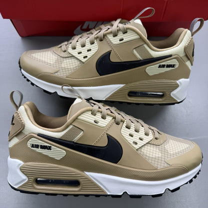 Nike Air Max 90 Drift beige trainers with black and brown accents, featuring logo detail.