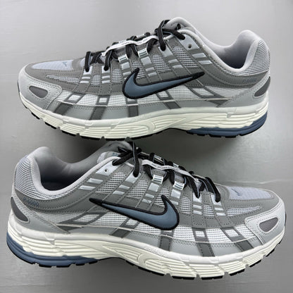 Nike grey trainers with blue accents and mesh material, featuring iconic swoosh logo.