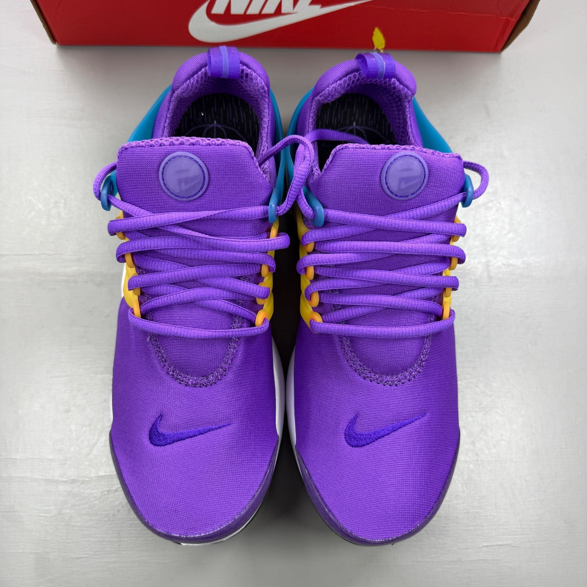 Nike Air Presto purple trainers with mesh upper and distinctive logo detailing.