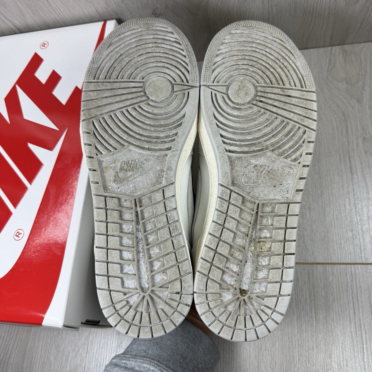 Nike Air Jordan 1 Low 85 grey trainers with white accents and iconic swoosh logo.