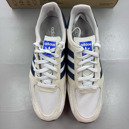 Adidas white LA Trainer sneakers with navy accents and classic three-stripe logo.