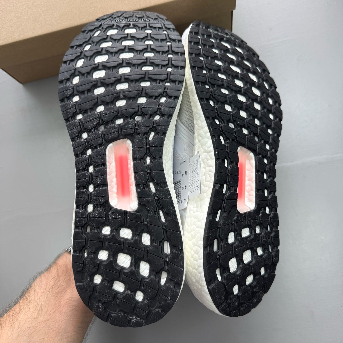 Adidas Ultra Boost 20 white running trainers with mesh upper and signature three stripes.