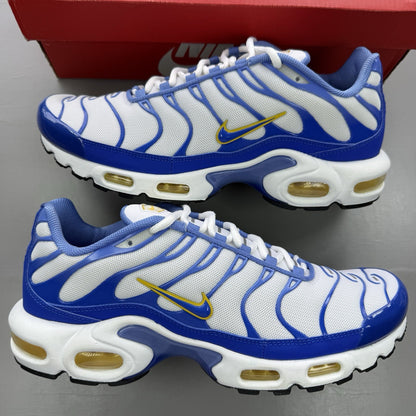 Nike Air Max Plus TN white trainers with blue and yellow accents, featuring logo detailing.