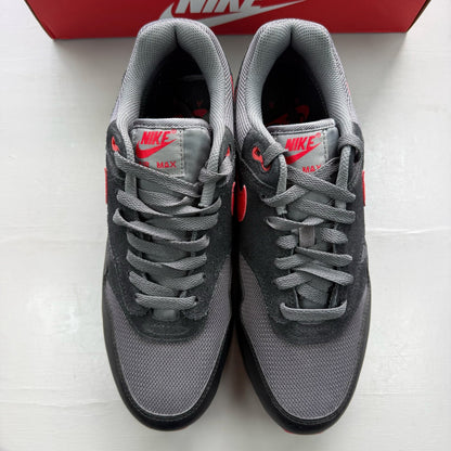 Nike black Air Max 1 trainers with red accents and logo detail.