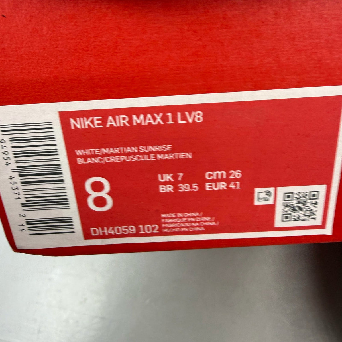Nike Air Max 1 white trainers with grey accents and Martian Sunrise detailing.