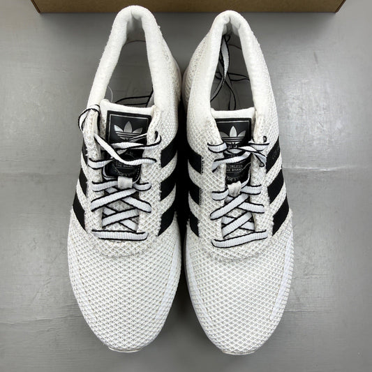 Adidas white running trainers with black accents and logo detail.