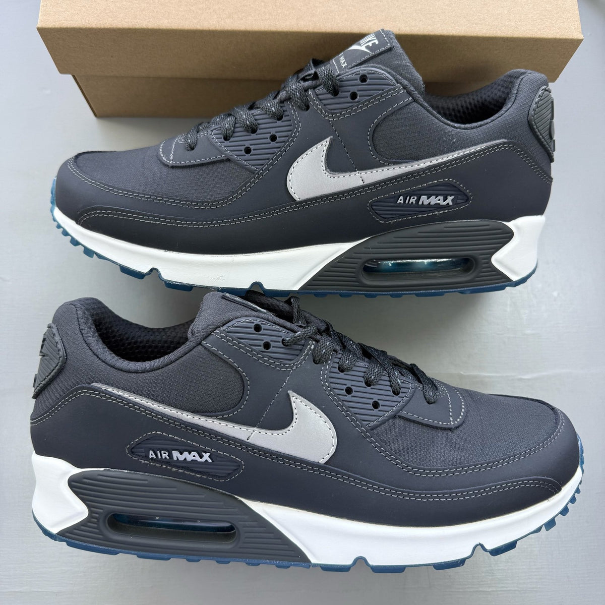 Nike grey trainers with reflective swoosh logo and anthracite detailing.