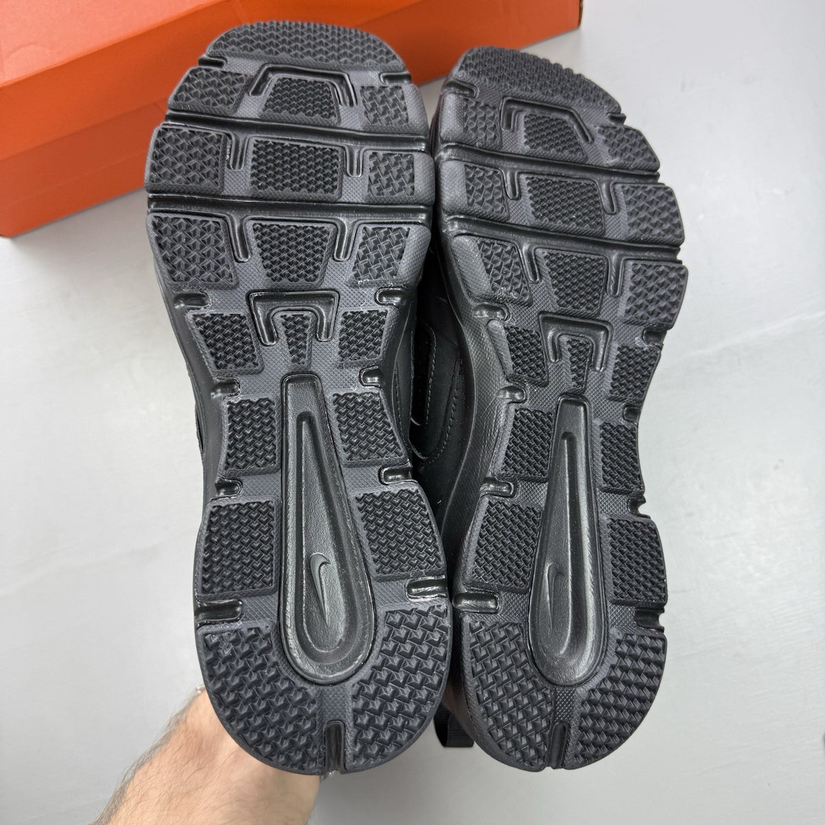 Nike black trainers with metallic silver accents and grey detailing, featuring logo on tongue.