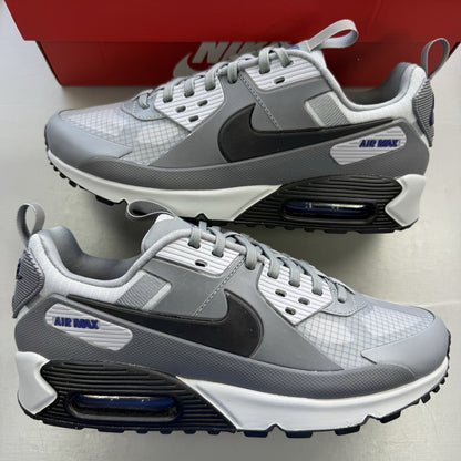 Nike Air Max 90 Drift grey trainers with deep royal blue accents and logo detail.