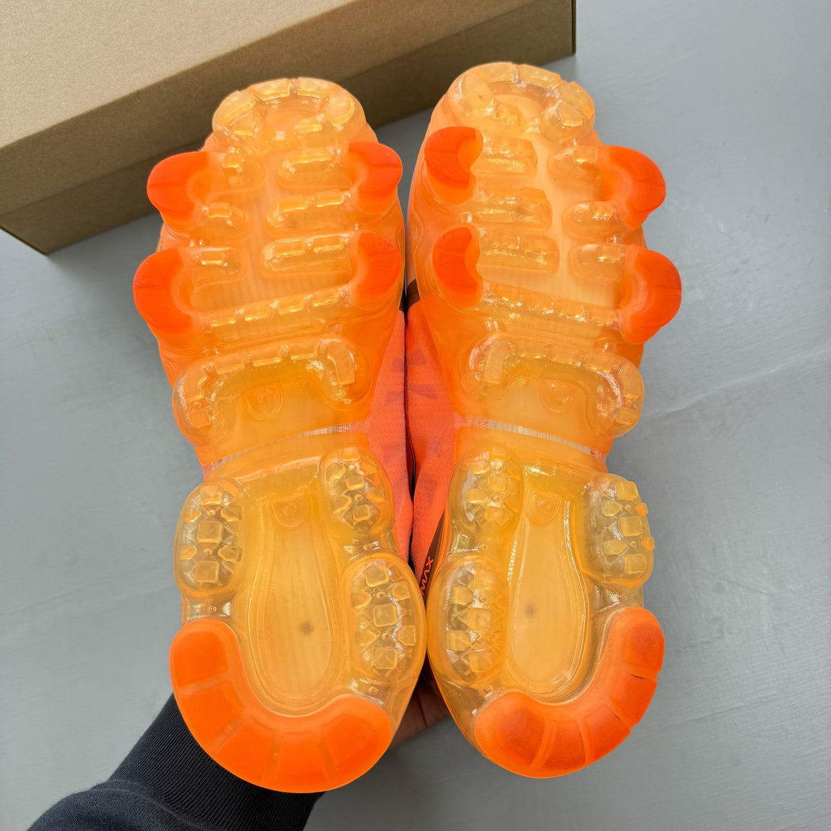 Nike grey trainers with total orange accents and Air VaporMax cushioning.