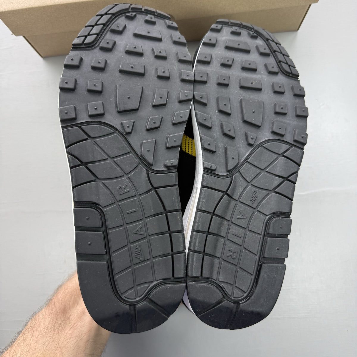 Nike Air Max 1 SE trainers black with tartan pattern and yellow accents.