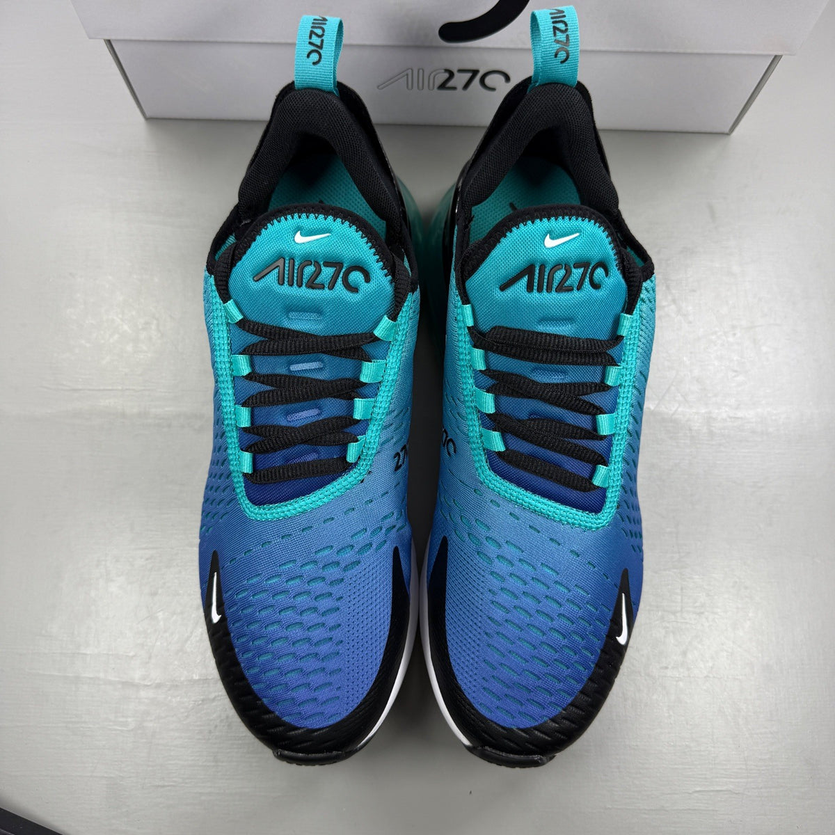 Nike Air Max 270 blue trainers with white accents and logo detailing.