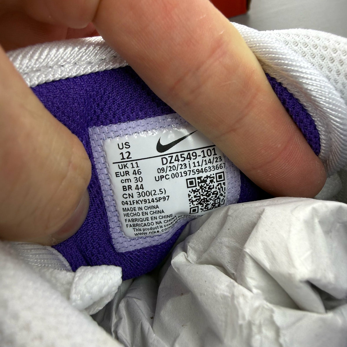 Nike Air Max 1 white trainers with purple accents and logo detail.