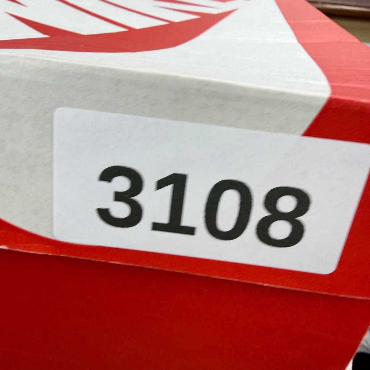 Nike Air Max 1 white trainers with burgundy accents and logo detail.