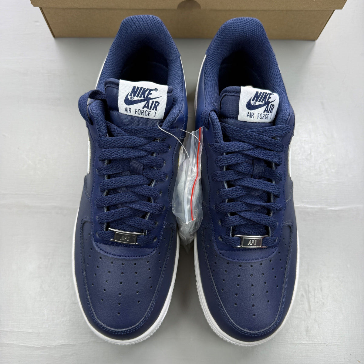 Nike trainers white with midnight navy accents and classic swoosh logo.