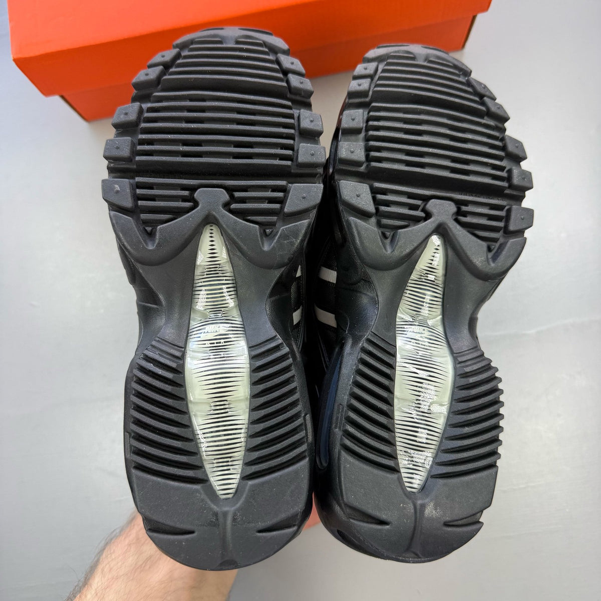 Nike Air Max 95 NDSTRKT black trainers with reflective detailing and logo accents.