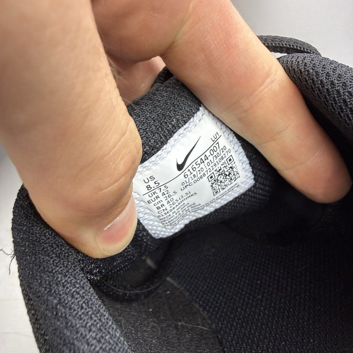 Nike black trainers with metallic silver accents and grey detailing, featuring logo on tongue.