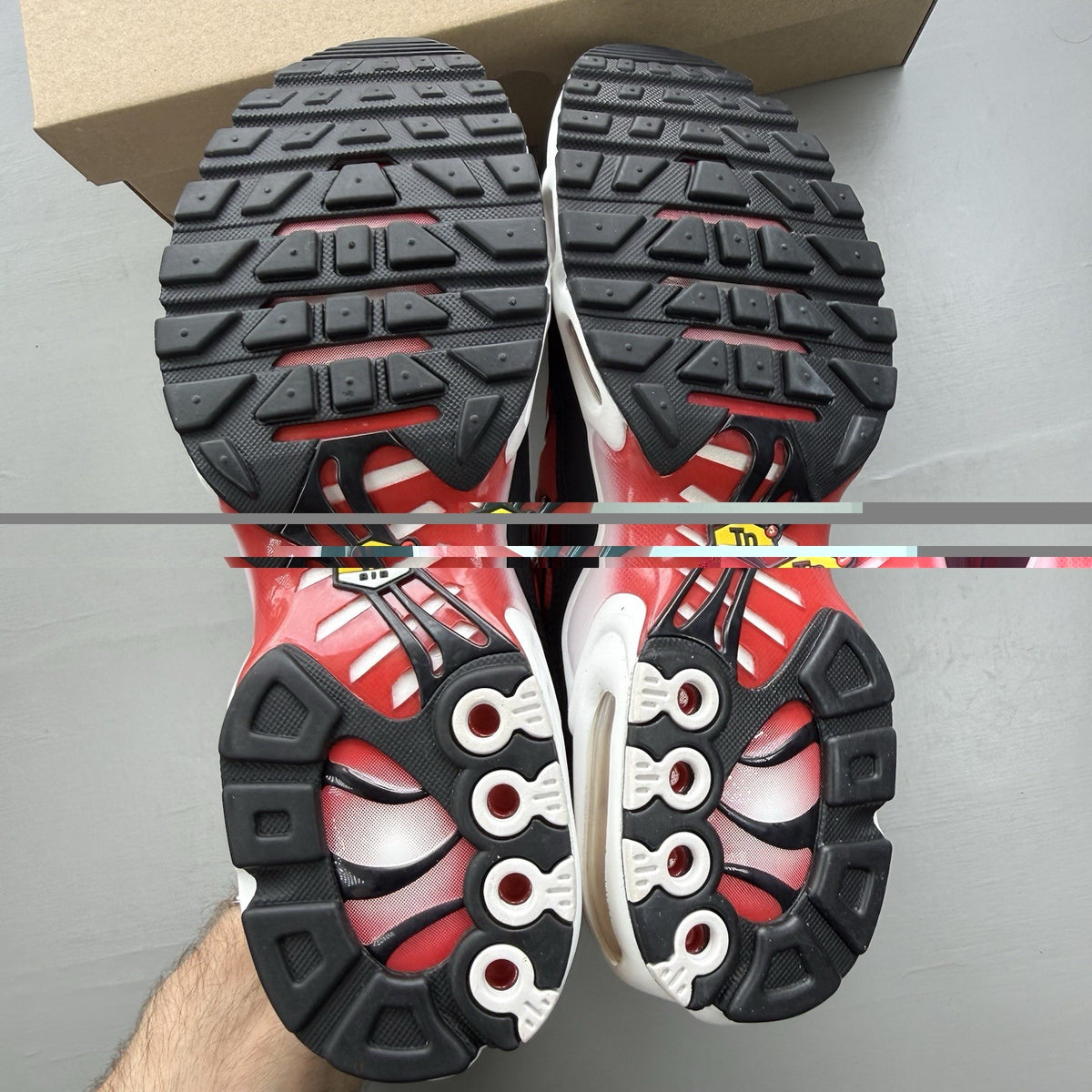 Nike Air Max Plus TN white trainers with black and university red accents, mesh material.