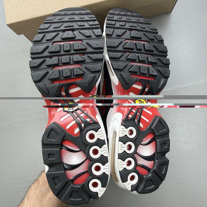 Nike Air Max Plus TN white trainers with black and university red accents, mesh material.