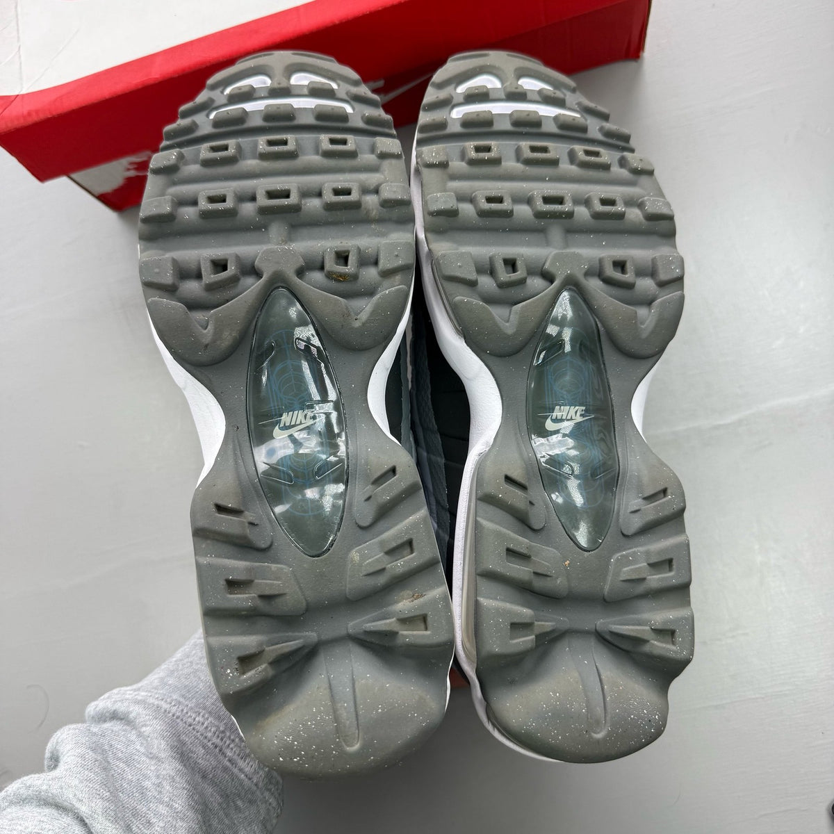 Nike Air Max 95 grey trainers with blue accents and visible logo detailing.