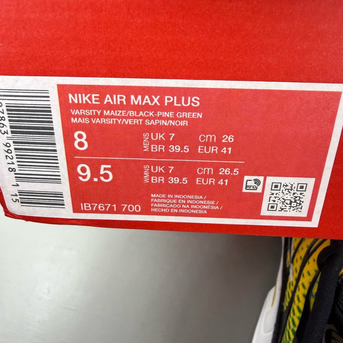 Nike black trainers featuring Air Max Plus design and vibrant yellow accents.