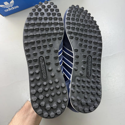 Adidas blue LA Trainer sneakers with white stripes and logo detailing.