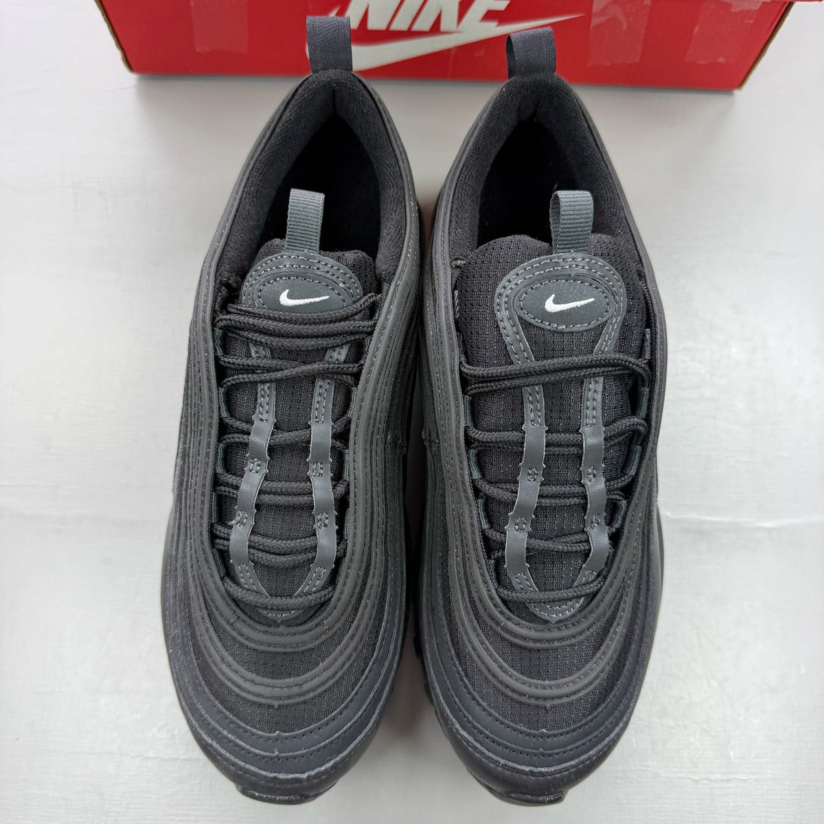 Nike Air Max 97 black trainers with anthracite accents and signature swoosh logo.