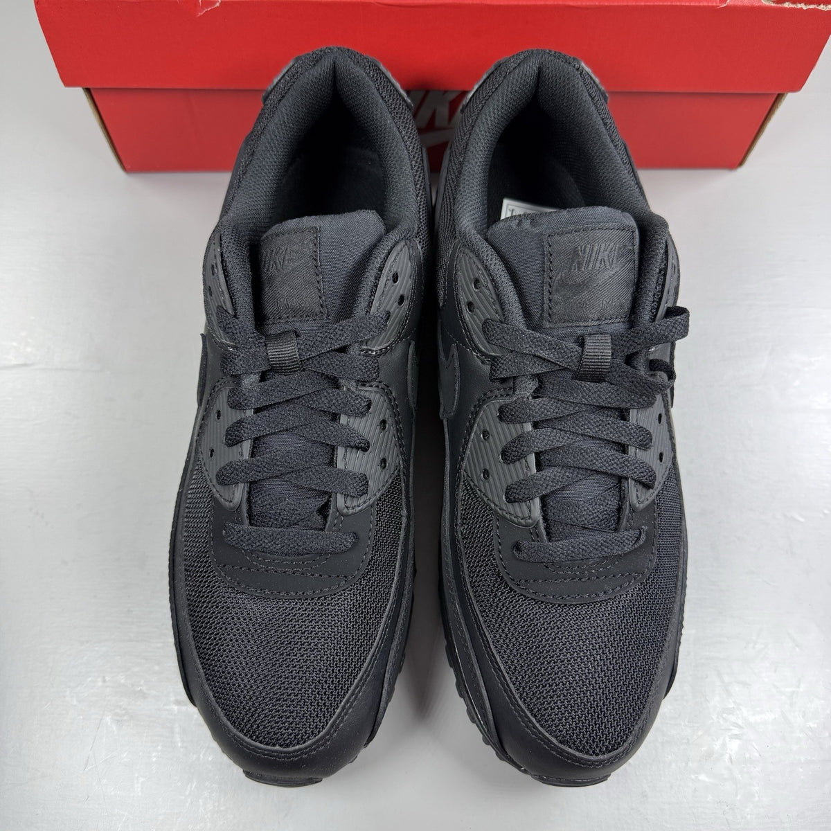 Nike Air Max 90 Recraft black trainers with textured upper and signature swoosh logo.