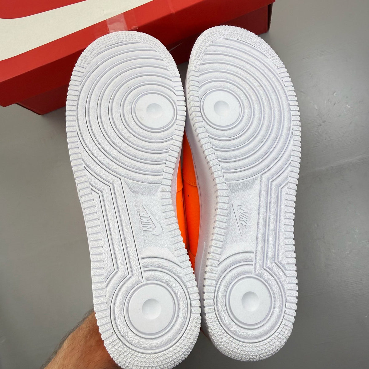 Nike Air Force 1 Low orange trainers with 'Just Do It' logo and sleek design.