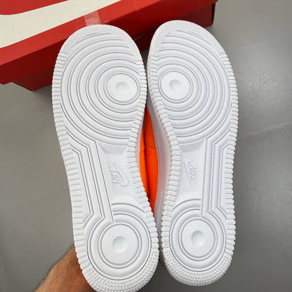 Nike Air Force 1 Low orange trainers with 'Just Do It' logo and sleek design.