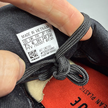 Adidas black trainers with grey accents and signature three-stripe logo.