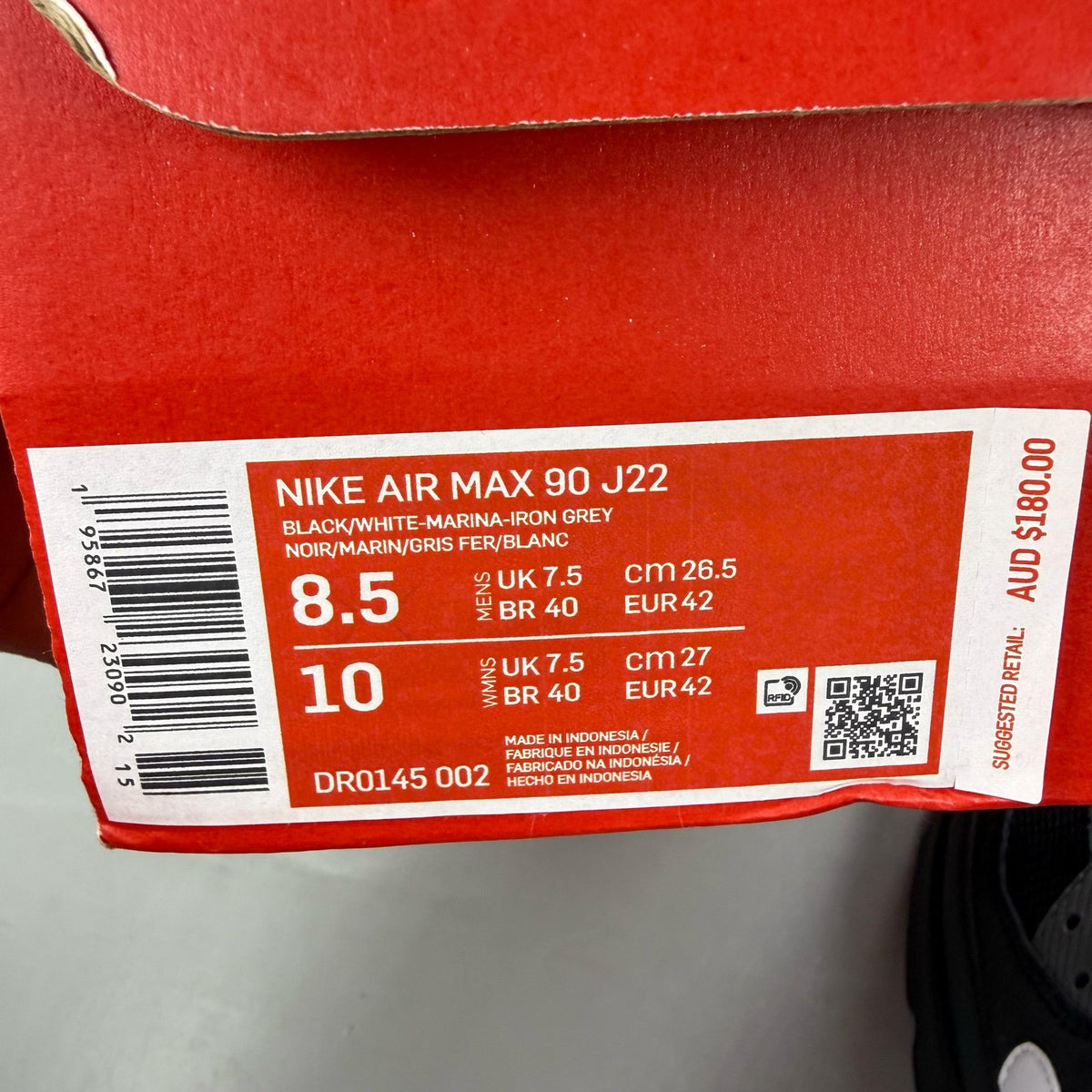 Nike Air Max 90 black trainers with grey accents and logo detail.