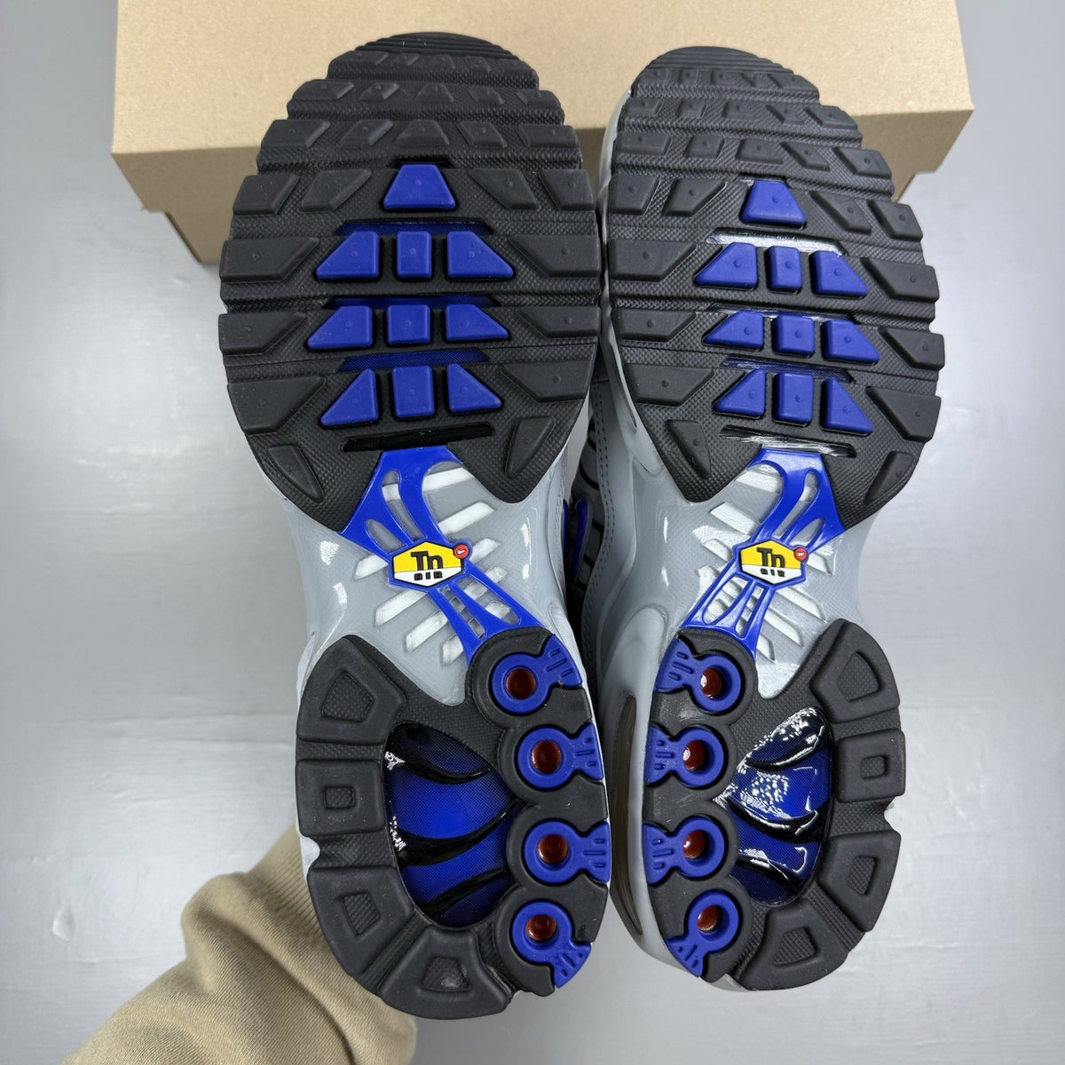 Nike Air Max Plus TN trainers grey with racer blue accents and unique design details.