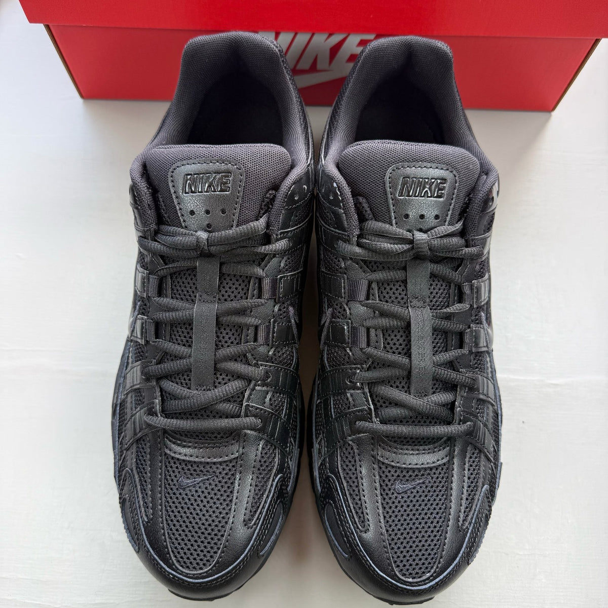 Nike black trainers with mesh upper and signature swoosh logo.