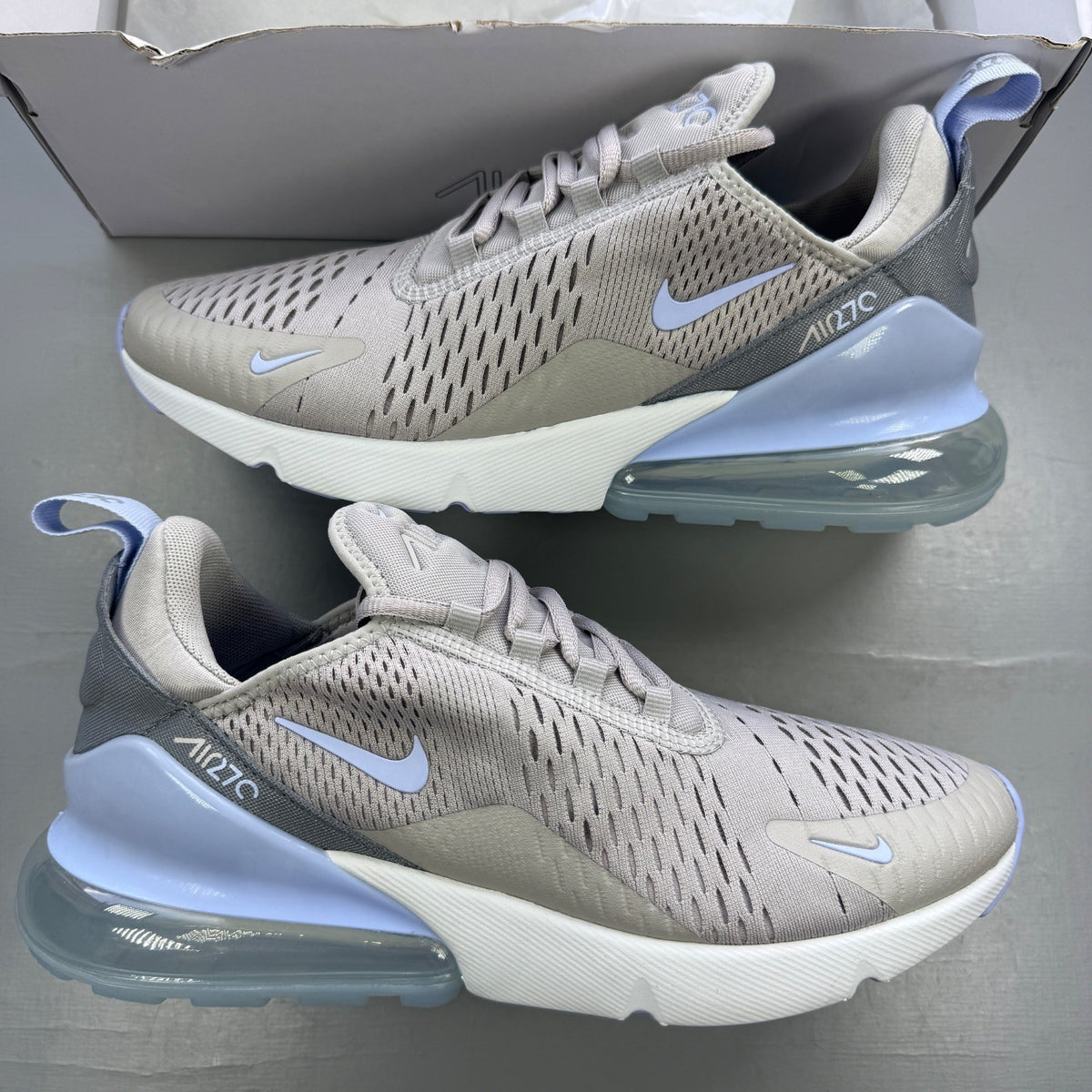Nike grey trainers with Air Max cushioning and logo detail on the tongue.
