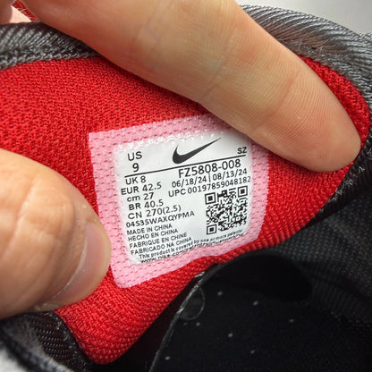 Nike black Air Max 1 trainers with red accents and logo detail.