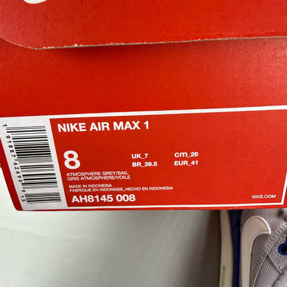 Nike Air Max 1 grey trainers with royal blue accents and signature logo.