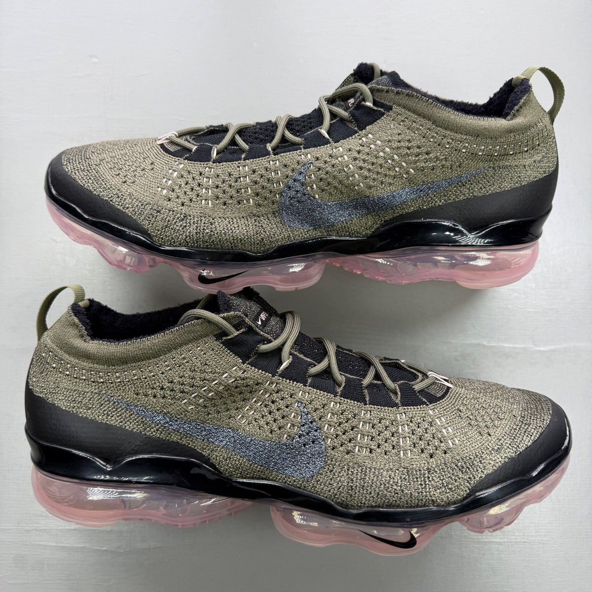 Nike trainers green Flyknit upper with pink accents and Air cushioning.