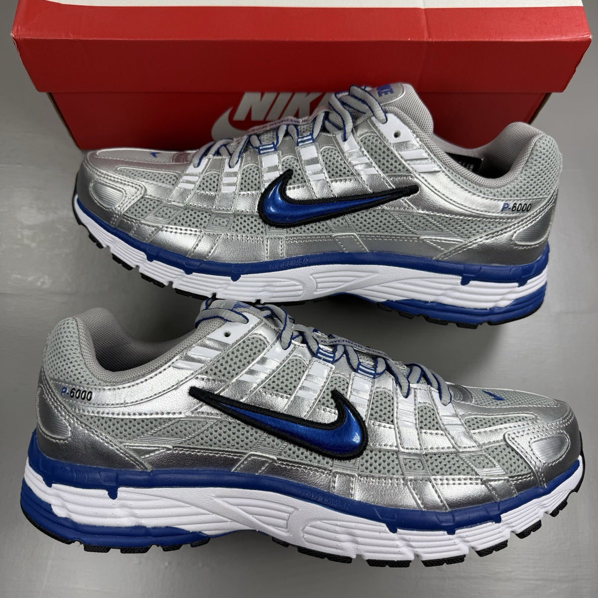 Nike P-6000 trainers white with laser blue and silver accents, mesh material, logo detail.