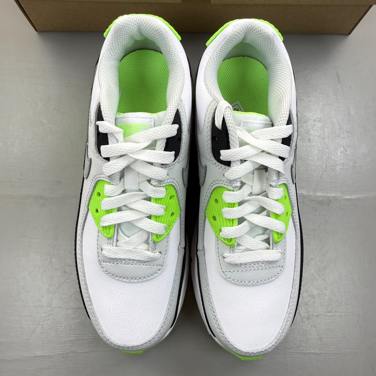 Nike Air Max 90 white trainers with black and lime blast accents, logo on tongue.