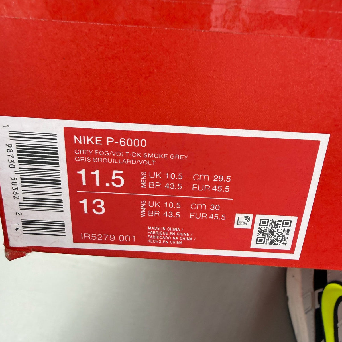 Nike P-6000 grey trainers with black accents and volt details, featuring iconic swoosh logo.