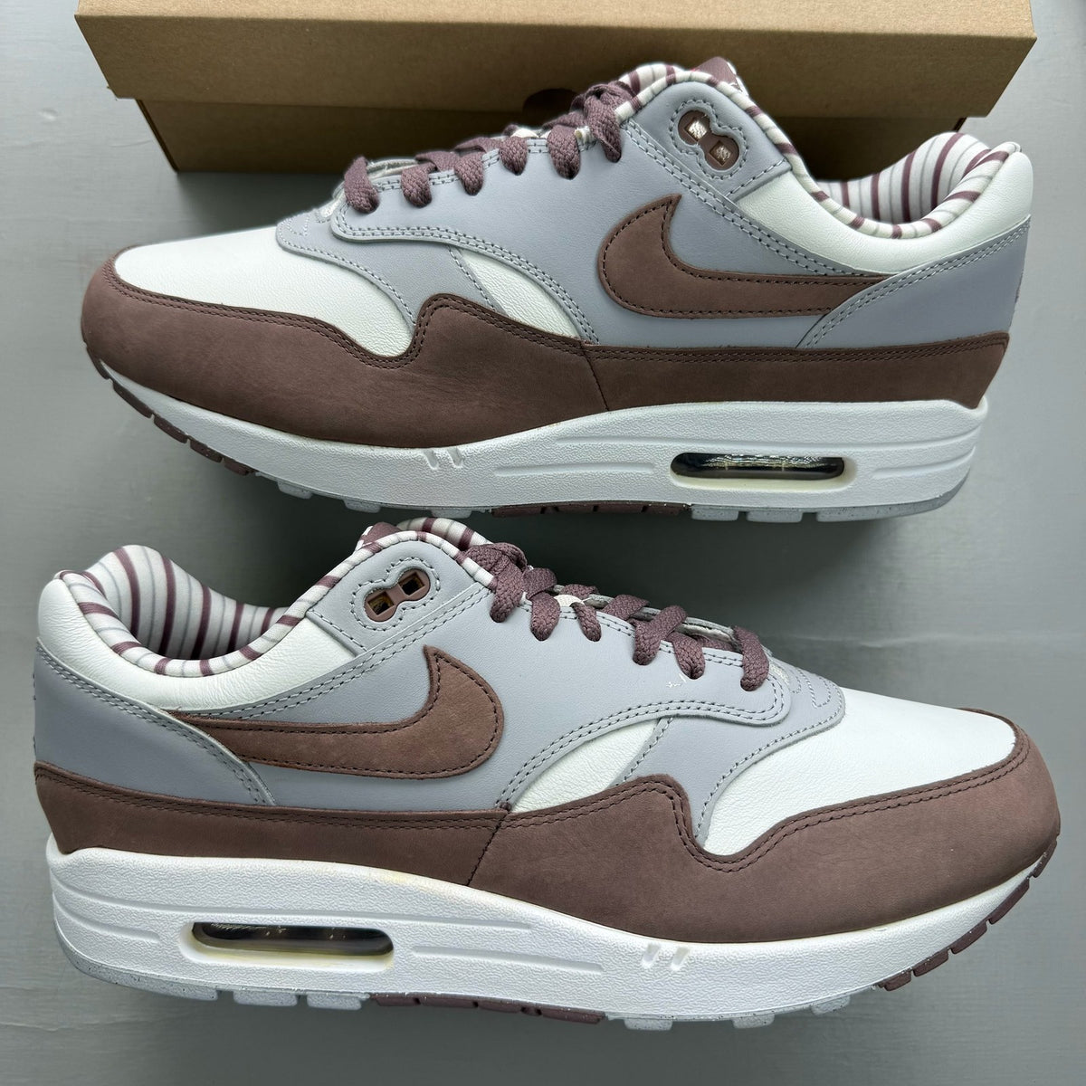 Nike Air Max 1 brown trainers with premium Shima Shima pattern and logo details.