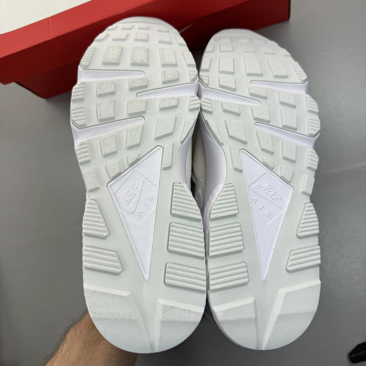 Nike Air Huarache Runner white trainers with red accents and signature logo.