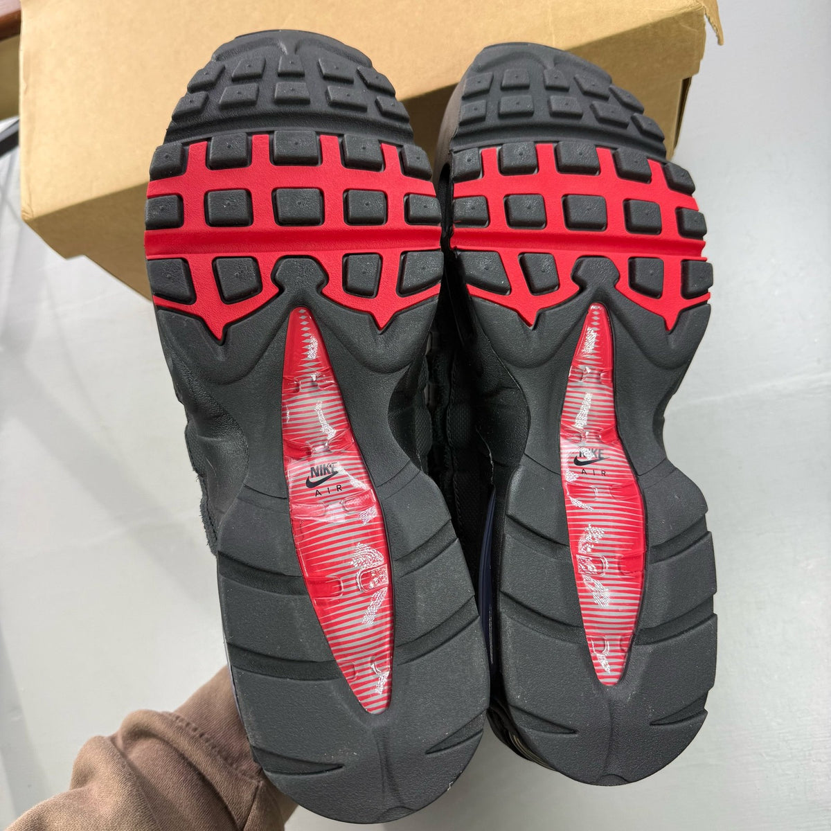 Nike Air Max 95 black trainers with red accents and signature big bubble sole.