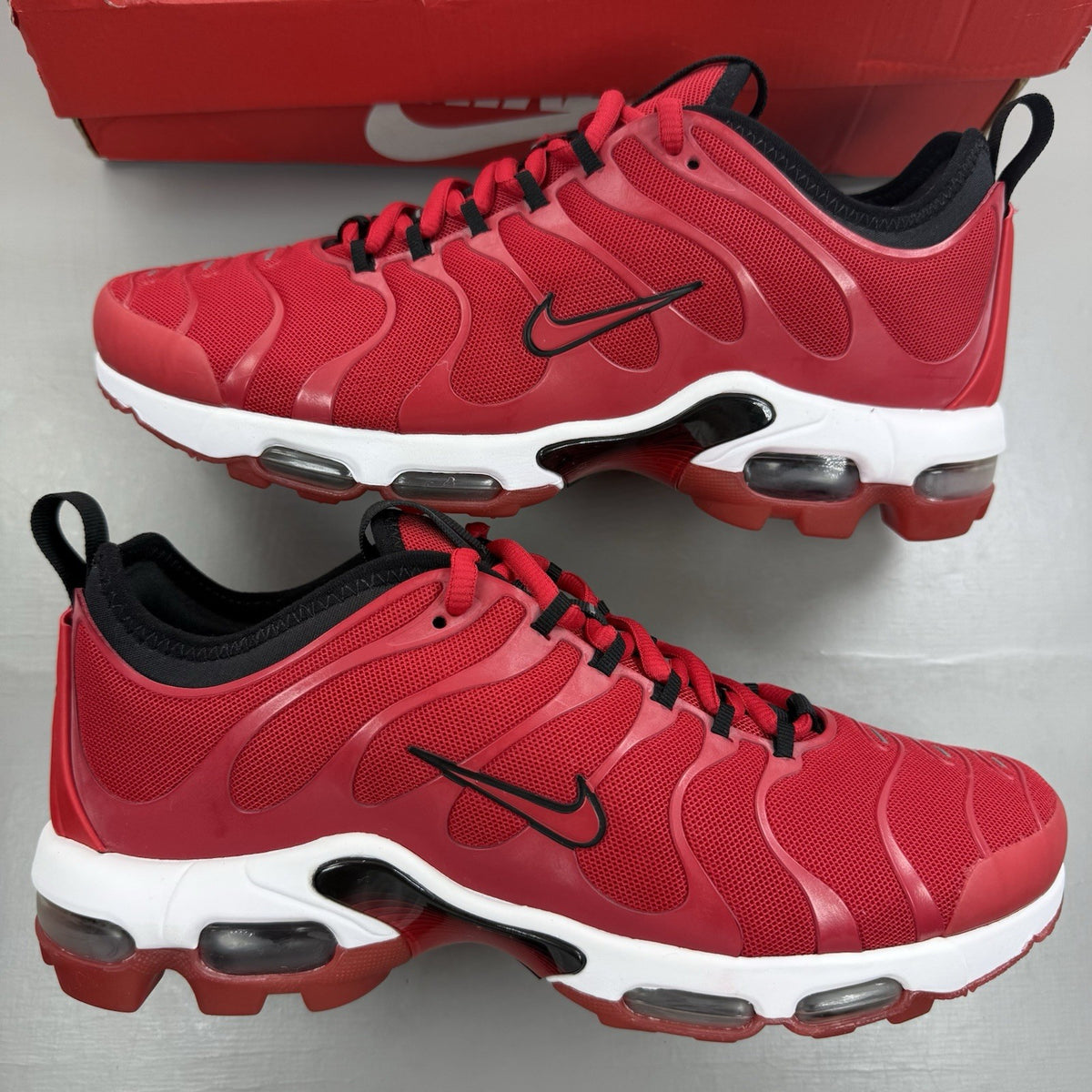 Nike Air Max Plus TN Ultra red trainers with black accents and signature logo.