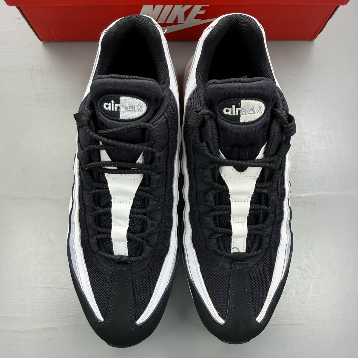 Nike Air Max 95 black trainers with grey and white accents, featuring iconic logo.