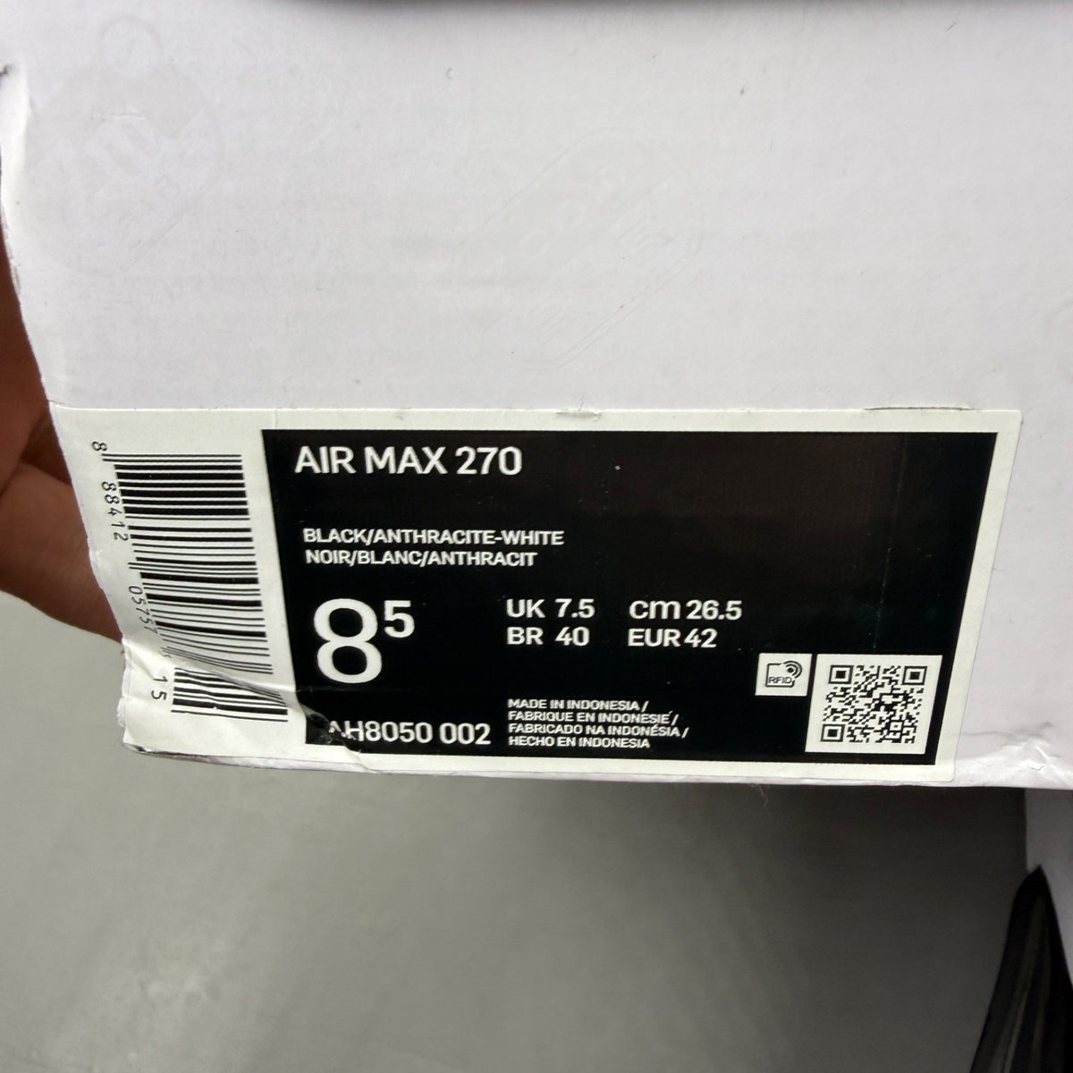 Nike Air Max 270 black trainers with white accents and logo detail.