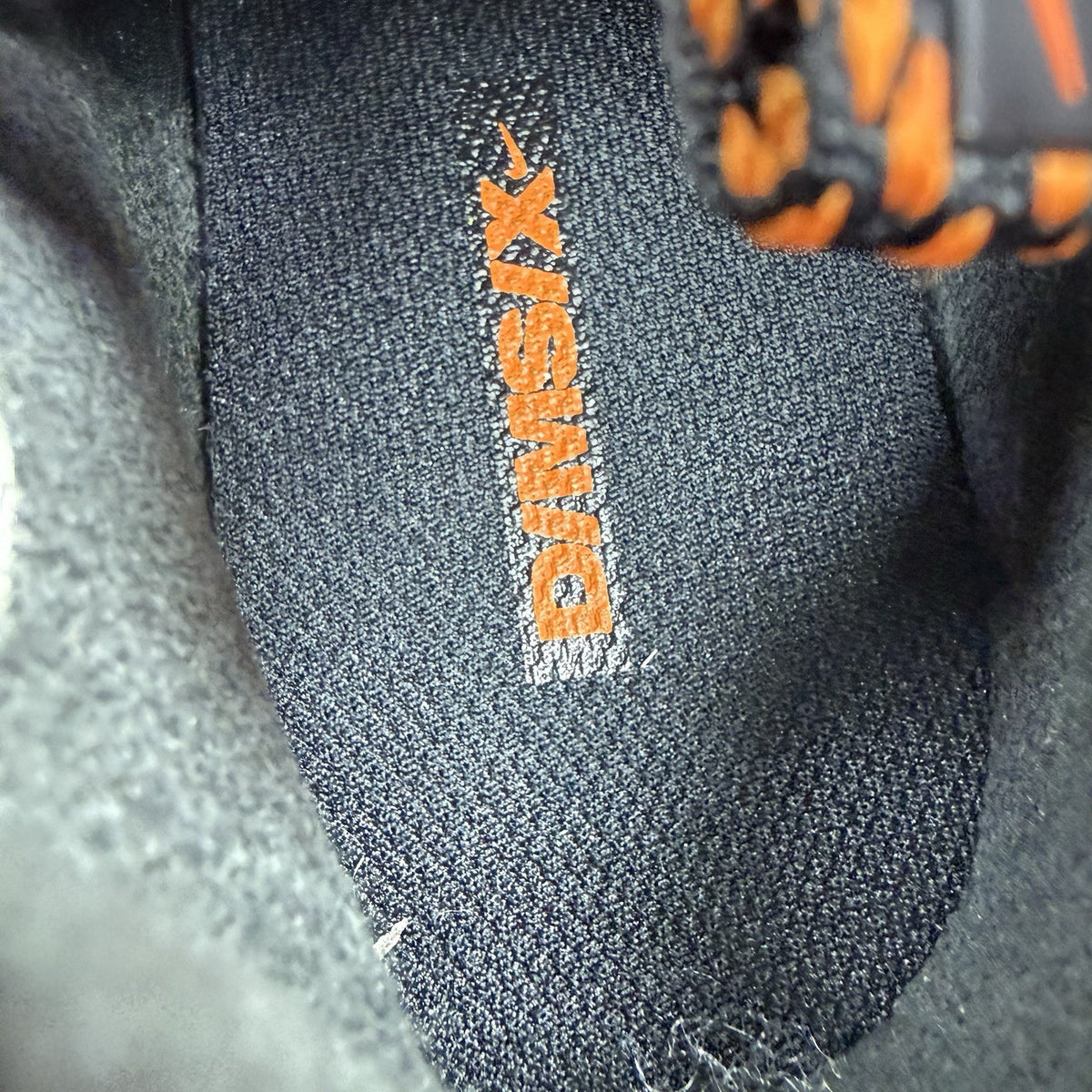 Nike React Vision black trainers with safety orange accents and unique design details.