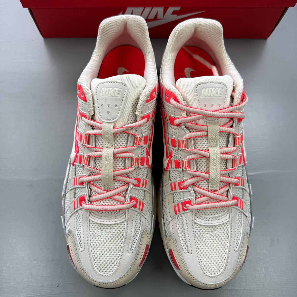 Nike P-6000 trainers white with red accents and mesh detailing, brand logo on tongue.